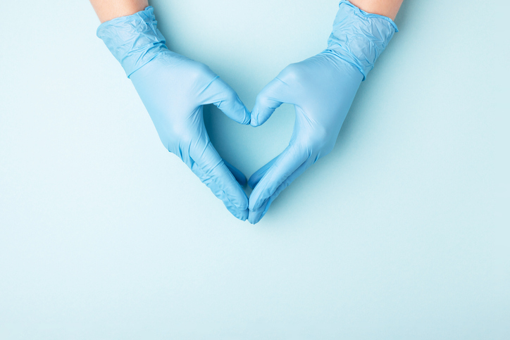 hands with gloves making a heart shape