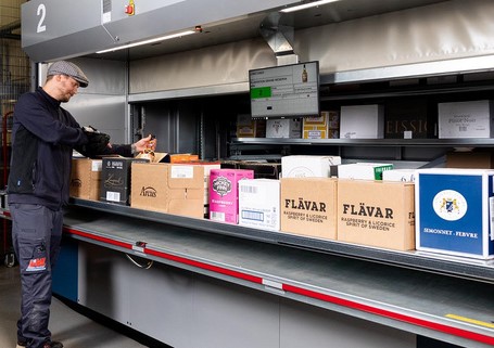 Man Operates Vertical Lift Module for Wine and Spirits Automated Storage 